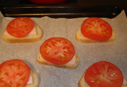 Поверх шинки з батоном викладаємо шматочки помідора
