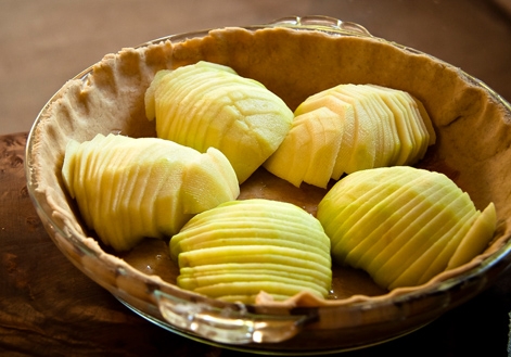 викладаємо нарізані половинки яблук у форму для запікання на корж